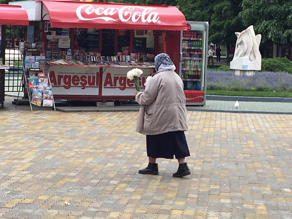 O bătrânică vinde narcise în centrul Piteștiului...
